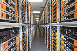 Eine lange Reihe von Servern in einem Rechenzentrum mit elektronischen Geräten in den Racks und Leuchten oben.