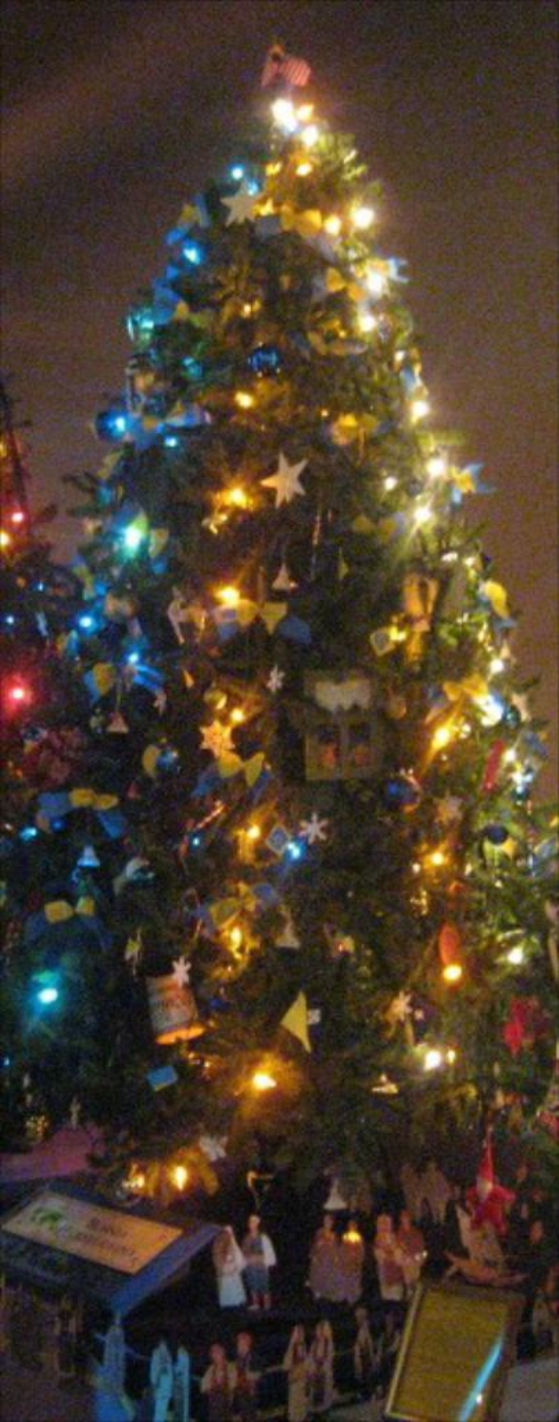 Ein geschmückter Weihnachtsbaum mit Statuen von Menschen darunter.