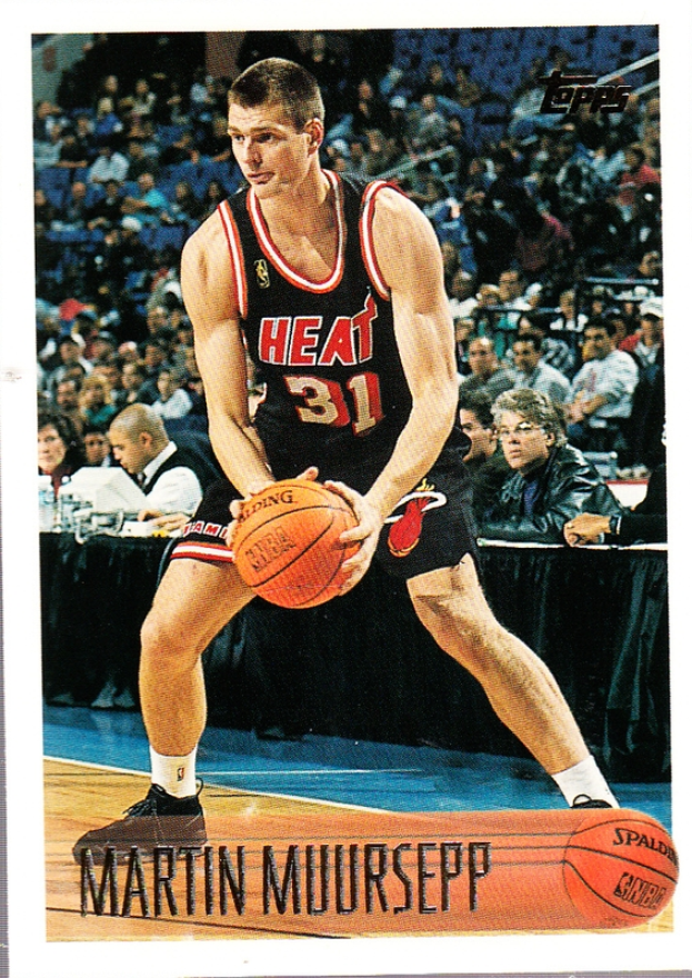 Martin Muursepp, ein ehemaliger Spieler der Miami Heat, hält einen Basketball in der Hand, umgeben von Menschen und einem Tisch im Hintergrund, und ein Textband unten mit der Aufschrift "1991-92 Topps Basketball Card".