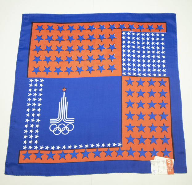 Ein blaues und orangefarbenes Bandana mit dem Olympischen Logo, vor einem weißen Hintergrund.