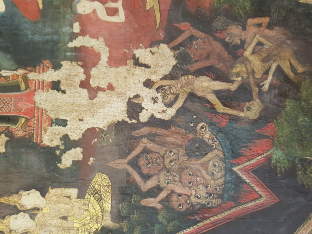 Ein farbenfrohes Wandgemälde in einem thailändischen buddhistischen Tempel, das eine Gruppe von Menschen in traditioneller Kleidung neben einem Löwen, Giraffe, Affe und Zebra zeigt, vor einer üppigen grünen Landschaft mit Bäumen und fernen Bergen.