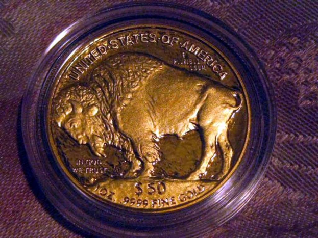Eine gold- und braune Münze mit der Aufschrift 'The United States Of America' auf einem braunen Teppichhintergrund.