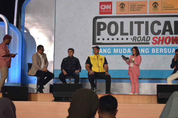 Eine Gruppe von Menschen sitzt auf einer Bühne mit einigen, die hinter einem Schild mit der Aufschrift "Cnn Political Road Show" stehen.