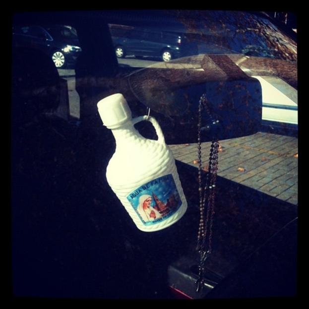 Ein Auto steht an der Seite einer Straße mit einer Kette und einer Flasche in der Nähe.