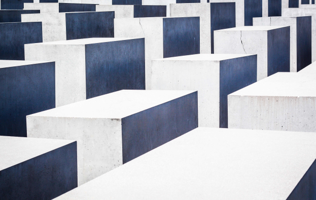 Eine große Anzahl weißer und blauer Blöcke, die in einem Muster angeordnet sind, am Holocaust-Mahnmal für die ermordeten Juden Europas in Berlin, Deutschland, schaffen eine feierliche und ernste Atmosphäre.