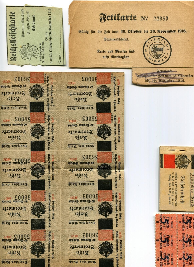 Sammlung alter, abgenutzter deutscher Tickets und Stempel auf weißem Hintergrund, einige mit gedrucktem Text und Zahlen.