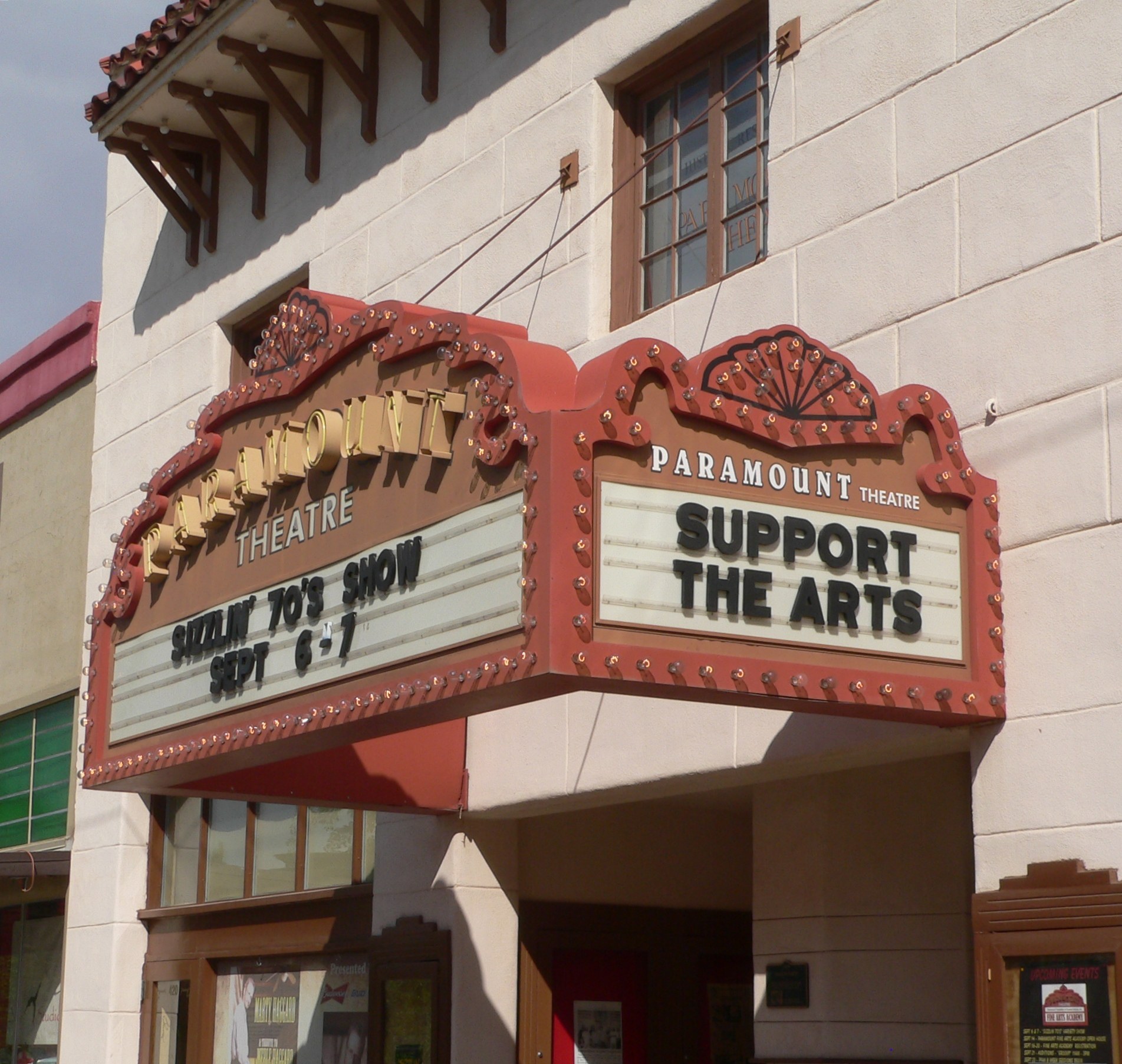 Außenansicht des Paramount Theatre in Sacramento, Kalifornien, mit Glasfenstern und -türen und einer 'Support the Arts'-Schrifttafel vor dem Himmel