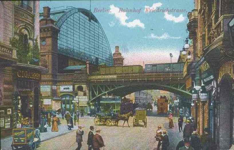 Alte Postkarte zeigt eine belebte Straßenzeile in Berlin, Deutschland, mit Fußgängern, Pferdewagen, Gebäuden, Laternen, einer Brücke und einem bewölkten Himmel, mit Text oben.