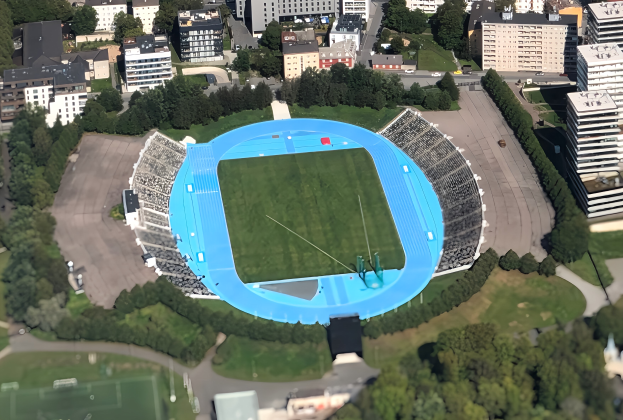 Luftaufnahme des Olympiastadions in München, Deutschland, umgeben von Gebäuden, Bäumen, Straßen, Fahrzeugen und Gras.
