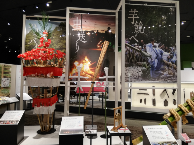 Ein Raum voller verschiedener Gegenstände, darunter Schilder mit Text, Stände und andere Objekte, mit Schildern mit Bildern und Text sowie Deckenleuchten, die eine festliche Atmosphäre für die Tokyo Toy Fair 2019 schaffen.