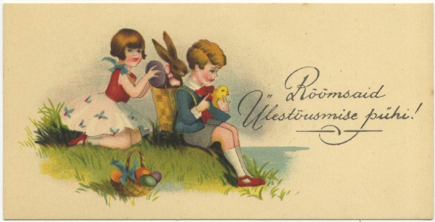 Schwarz-weiß-Postkarte mit zwei Kindern auf dem Gras, eines hält einen Korb mit Ostereiern und das andere ein Spielzeug, im Hintergrund ein Plakat mit Text.