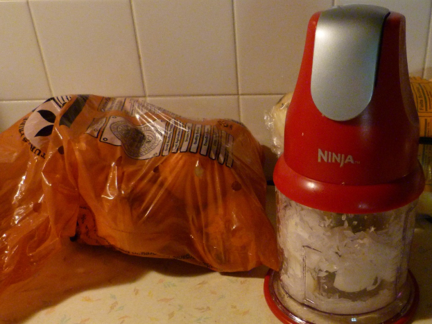 Ein Mischer mit einem Paket von Gegenständen darin, einem Gegenstand daneben und einem Fliesenhintergrund.