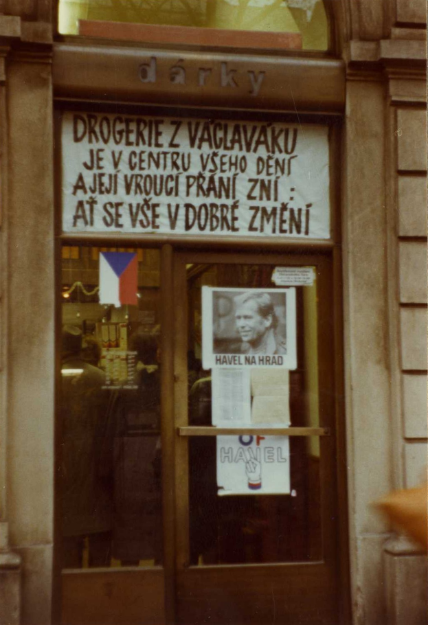 Ein altes Foto einer Glastür mit einem Schild, einem Plakat einer Person und einigen aufgeklebten Papieren.
