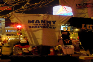 Eine Gruppe von Menschen in T-Shirts vor dem Hintergrund von Ampeln, Bäumen, Pfählen und Gebäuden.