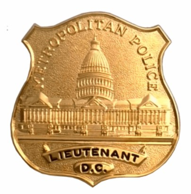 Goldenes Polizeimarke mit der Aufschrift "Leutnant DC" auf einem weißen Hintergrund.