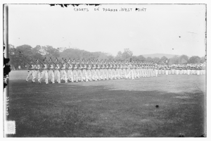 Gruppe von Menschen auf dem Boden stehend, einige halten Gewehre, mit Bäumen, Hügeln und einem bewölkten Himmel im Hintergrund, beschriftet "cadets on parade west point" oben.