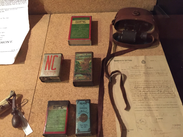 Ein Korkbrett mit verschiedenen darauf befestigten oder angehefteten Gegenständen, darunter Kartons, Papiere und eine Tasche.