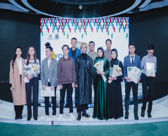 Gruppe von Menschen auf einer Bühne mit Blumensträußen und Urkunden, im Hintergrund ein "Jugend-Solar-Awards 2019"-Schild
