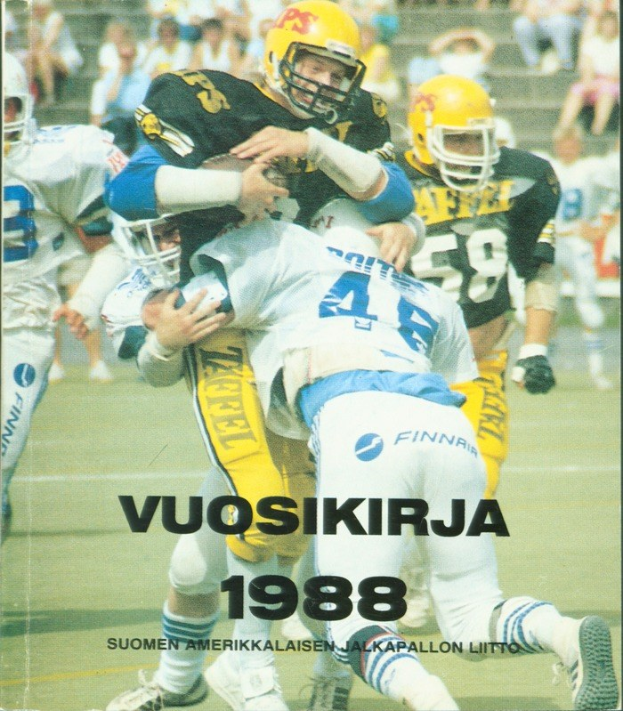 Gruppe von Menschen in Sportbekleidung und Helmen, die auf einem Feld Fußball spielen, mit Zuschauern auf einer Treppe im Hintergrund; Text unten lautet "Vuosikirja 1988 - Suomen Amerikkaisen Jalkapallon Litto".