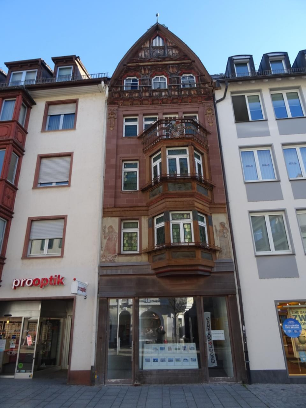 Gewerbegrundstück mit zahlreichen Fenstern zum Verkauf, gelegen an einer Straße in Heidelberg, Deutschland, unter einem klaren blauen Himmel.