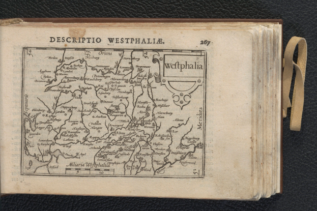 Ein aufgeschlagenes Buch mit einer detaillierten Karte der geografischen Merkmale Westfalens auf einer schwarzen Oberfläche.