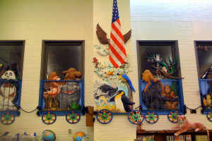 Ein Gebäude mit einer Wand, Flagge, Spielzeugen, Büchern, Globus und anderen Gegenständen in der Mitte des Bildes.